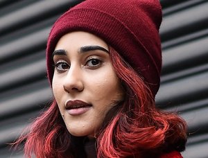 Young woman wearing a red bobblehat with cherry red hair